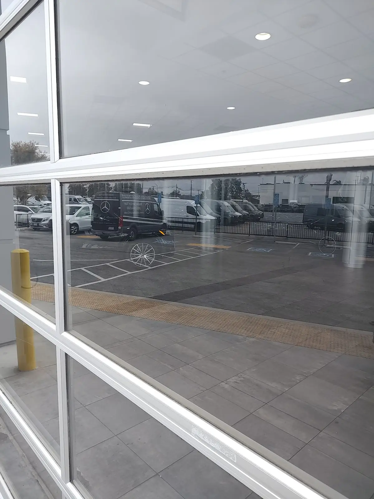 Bent Nail technician repairing a commercial glass entry door at a dealership in Oxnard, CA