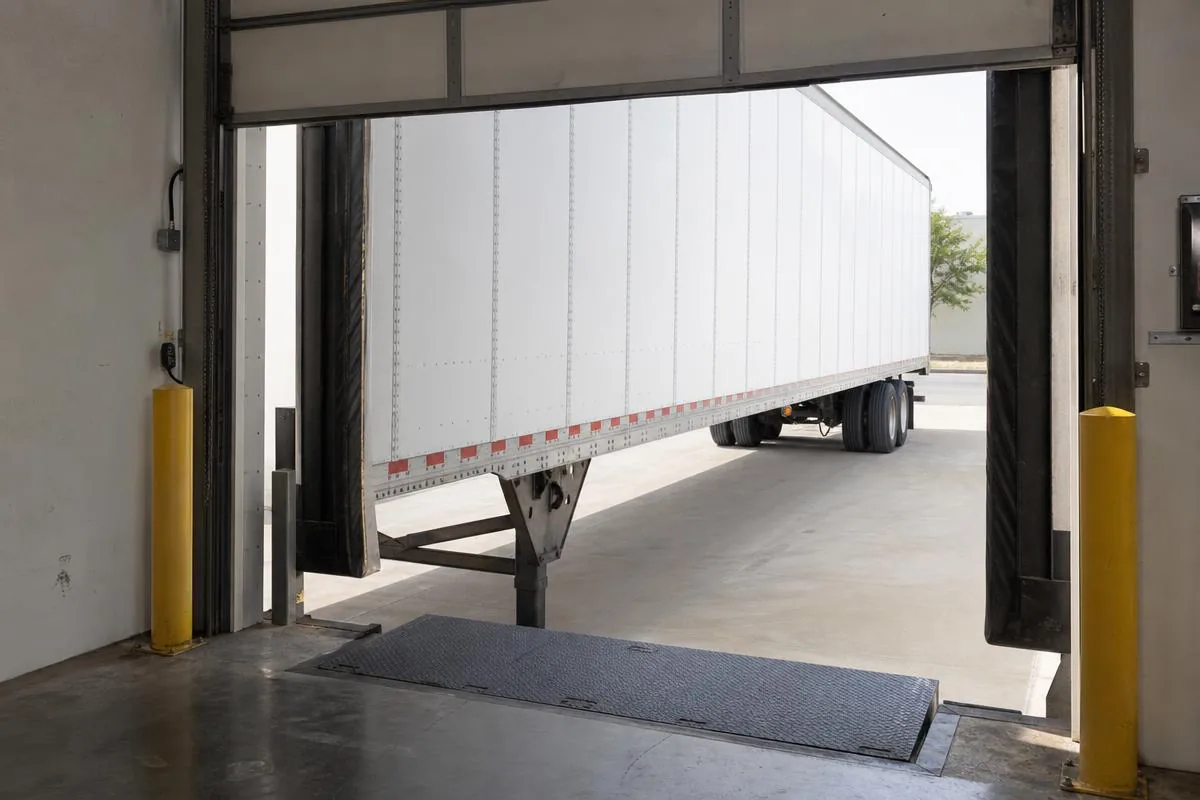Warehouse loading dock door, bumpers and dock leveler with a trailer backed into the bay in Ventura County, CA